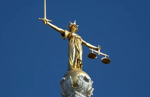 This is a picture of statue of justice at the Old Bailey. The statue of justice is a lady with a raised sword in one hand and scales in the other hand