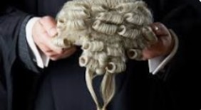 The title is Crown Court Clerks and the picture is of two hands holding a judges wig